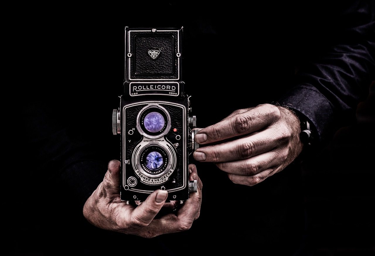 Historický fotoaparát v rukách človeka ktorý fotí.